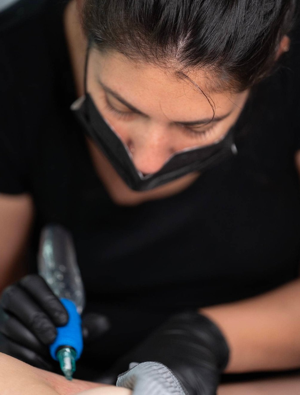 Artist preparing tools for a fine-line tattoo
